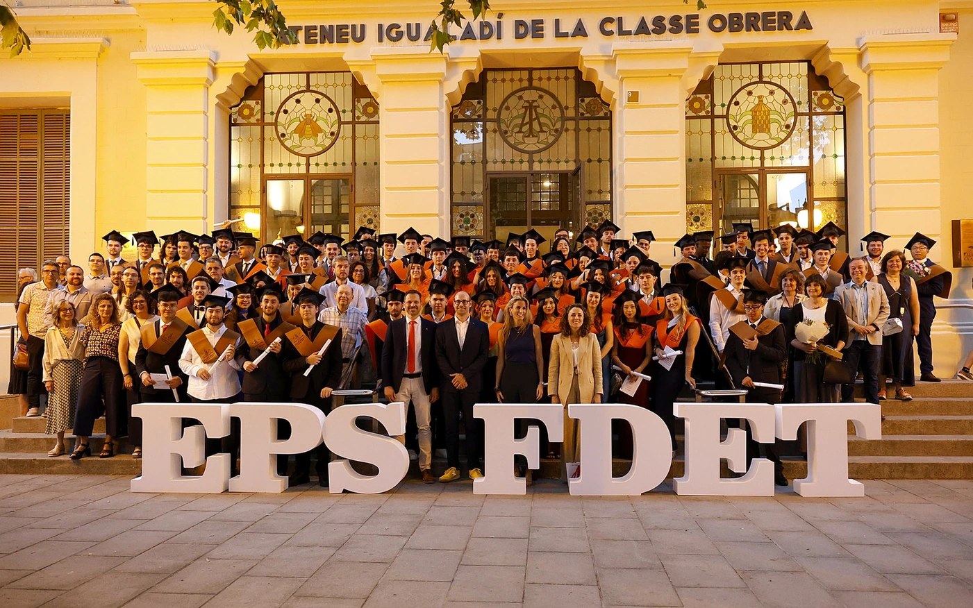 Graduados de la EPS y la FDET de la UdL con toga y birrete frente al Ateneu Igualadí