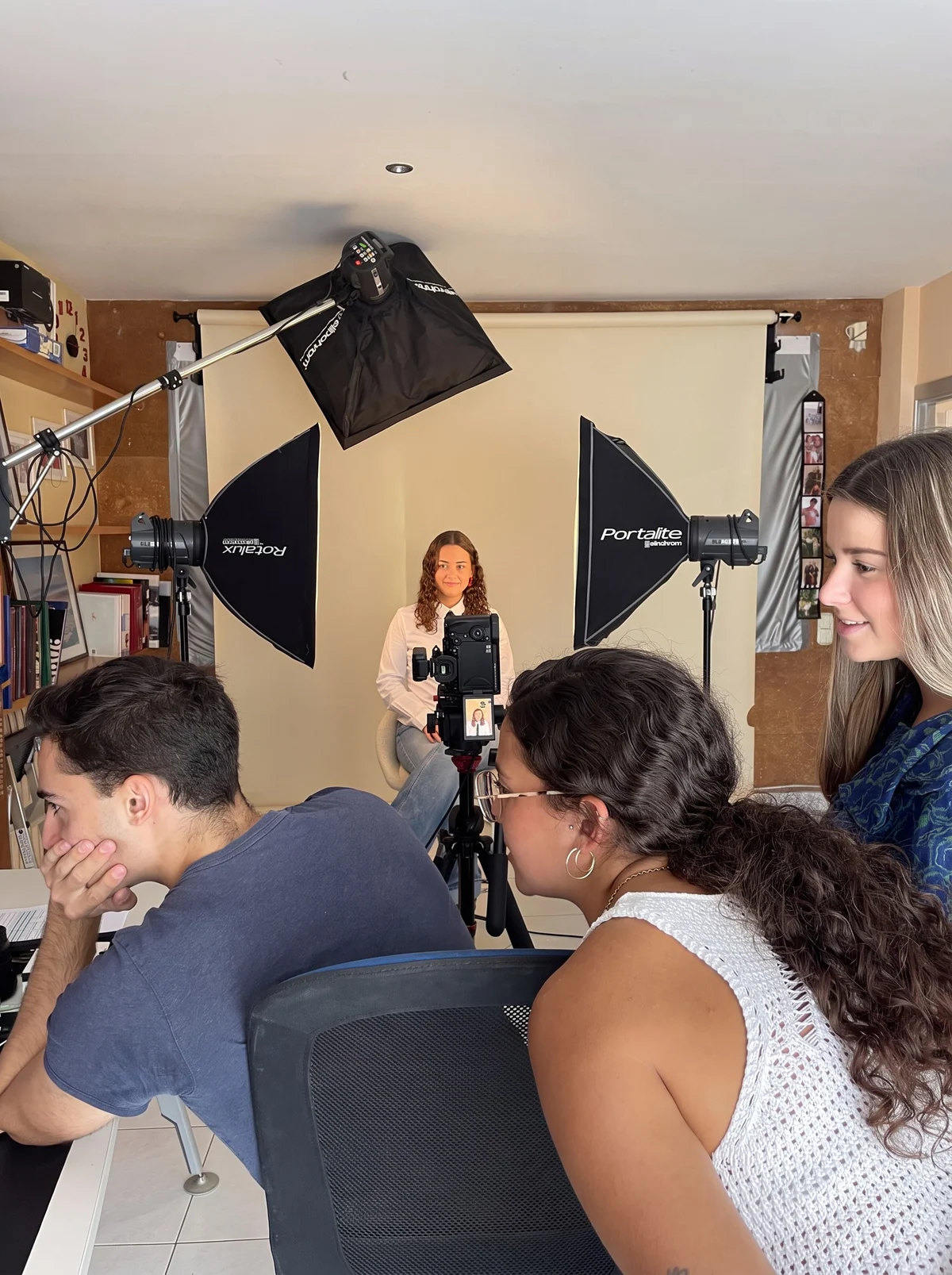 Pau enseña a los compañeros en la pantalla de la cámara cómo va la sesión de fotos en el estudio