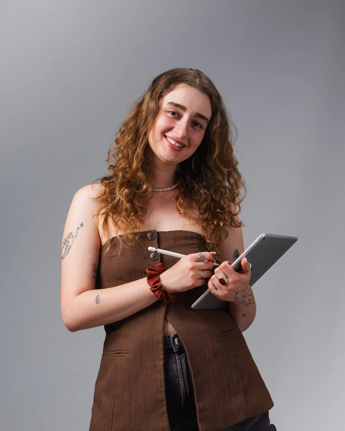 Carla sonríe con una tableta y un lápiz digital en las manos