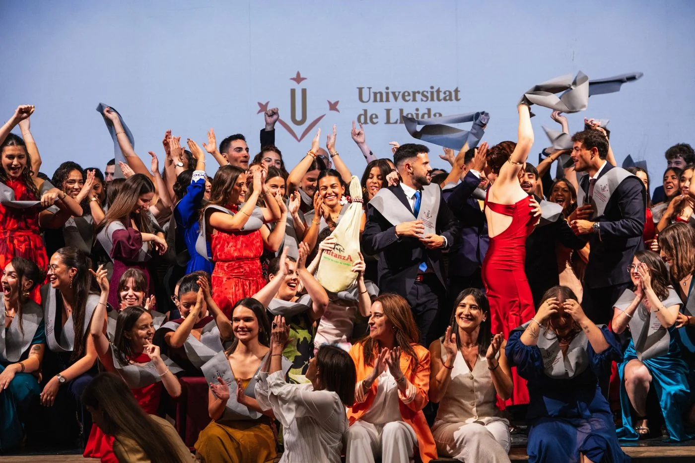 Graduados de Enfermería celebran agitando las bandas