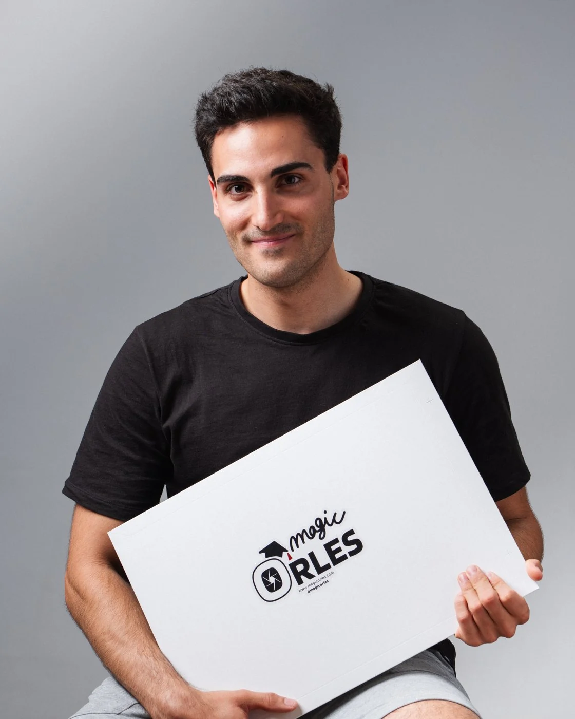 Pau sonríe sujetando un sobre de entrega con el logo de MagicOrles