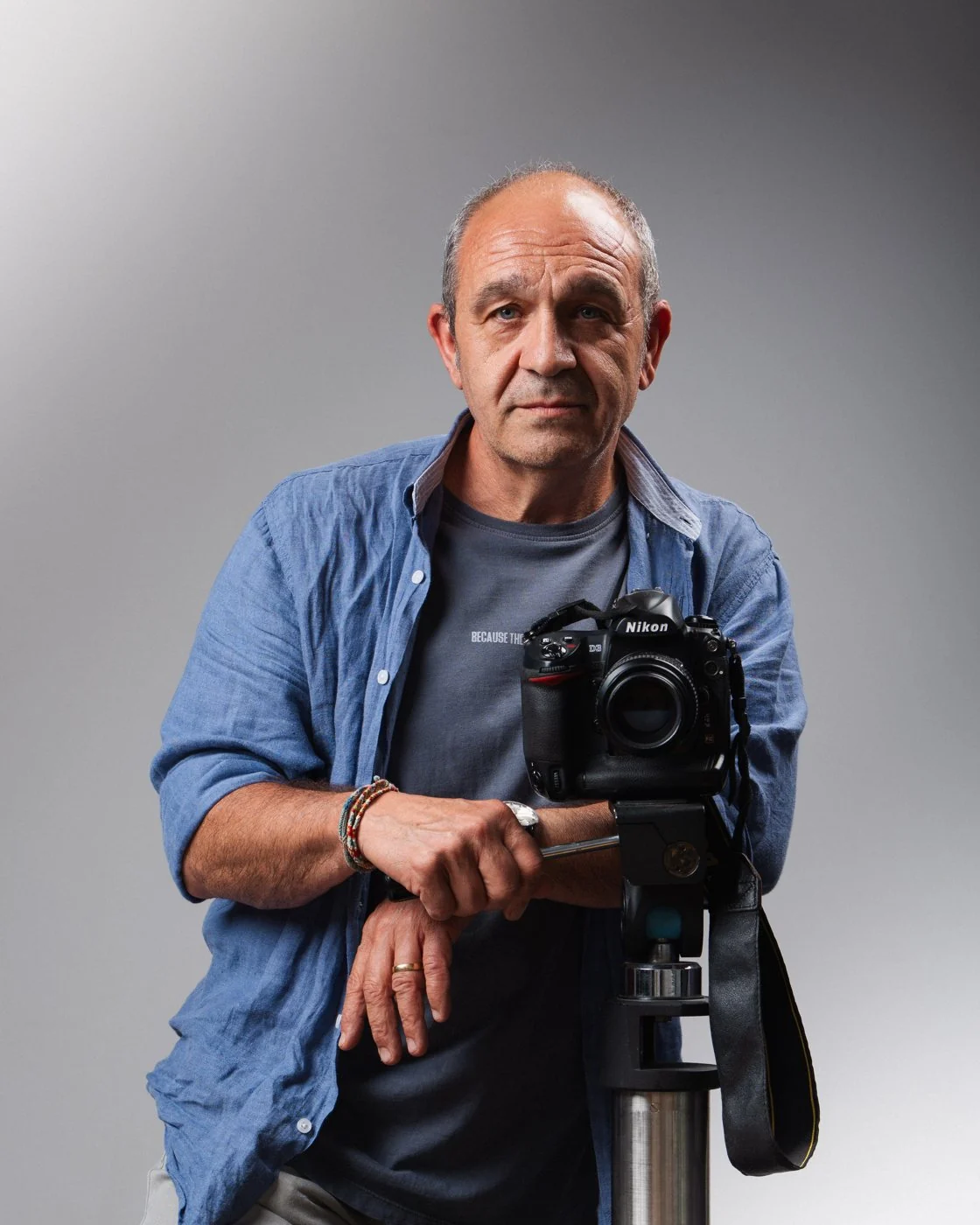 Pep, fotógrafo, apoyado en un trípode con su cámara en el estudio